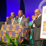 Raphael Warnock (center, at the microphone), pastor of Ebenezer Baptist Church in Atlanta, Ga., and chair of the social justice commission for the Progressive National Baptist Convention, leads a call for the restoration of rights lost when the U.S. Supreme Court overturned portions of the Voting Rights Act of 1965. He is joined by (left to right) Charles Steele, president and CEO of the Southern Christian Leadership Conference; Ambassador Andrew Young, director of the Drum Major Institute for Public Policy; Frederick Douglass Haynes III, pastor of Friendship-West Baptist Church in Dallas; and James Perkins, president of the Progressive National Baptist Convention. (PHOTO / Ken Camp)